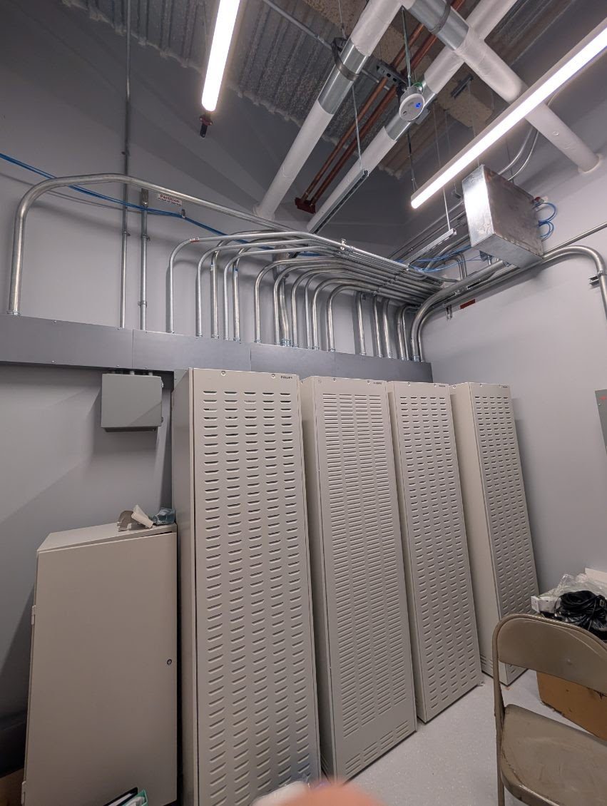 Conduit runs and equipment cabinets in a commercial electrical room by VECA